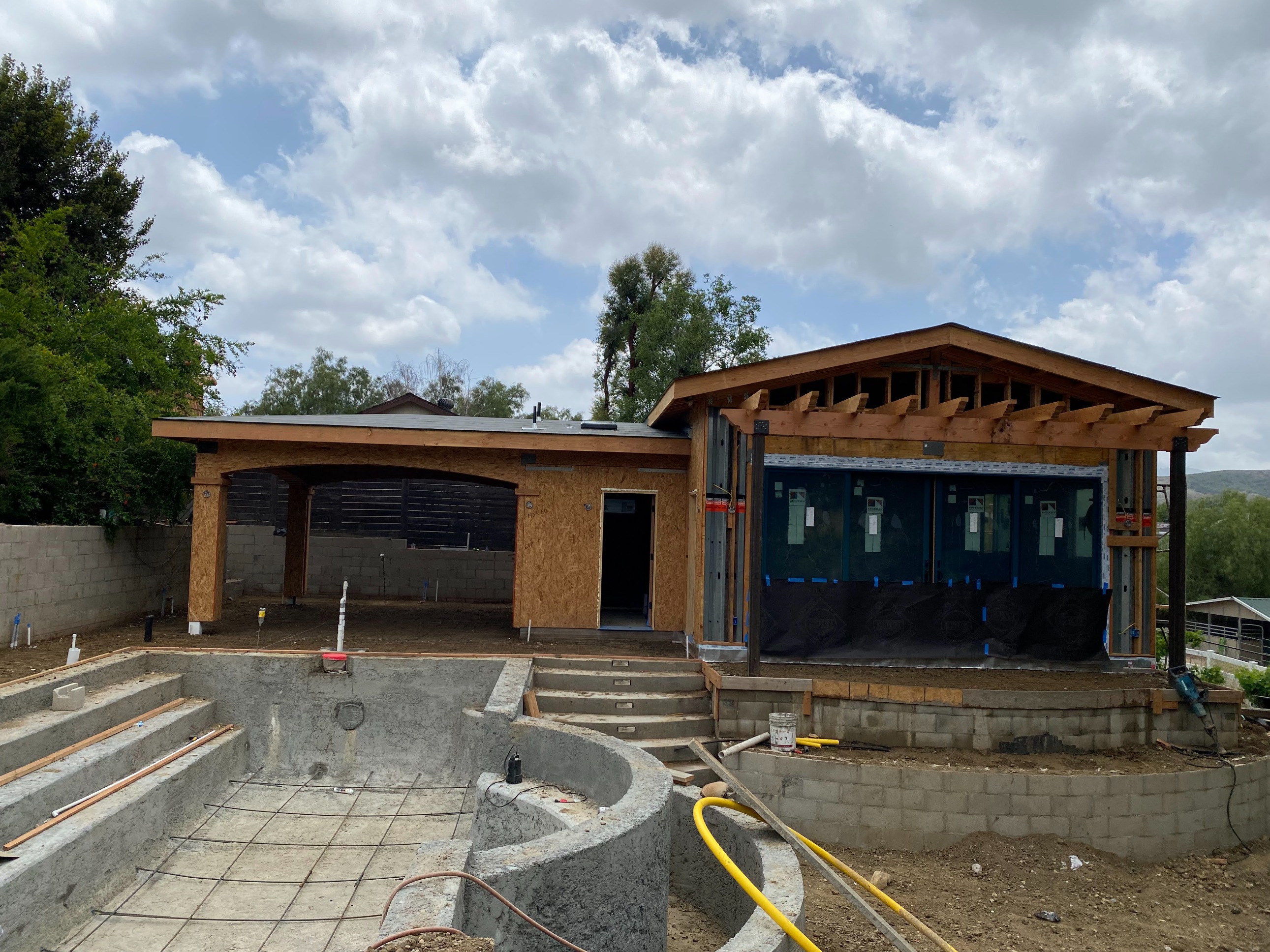 Ground-up construction in progress — framing the luxury ADU and shaping the resort-style pool.