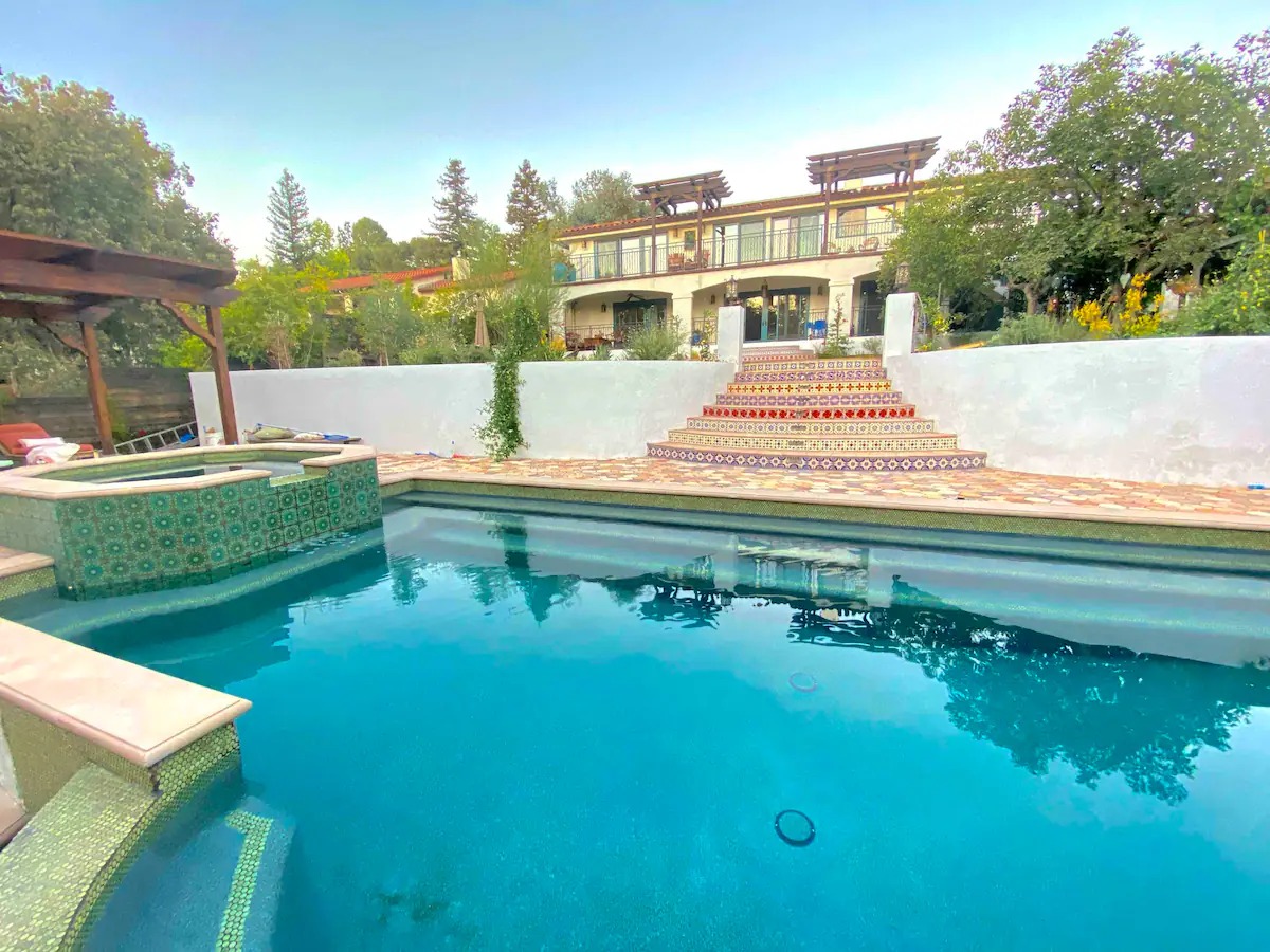 Hand-set Spanish tile, multi-level terraces, and a custom pool create a true California courtyard experience.