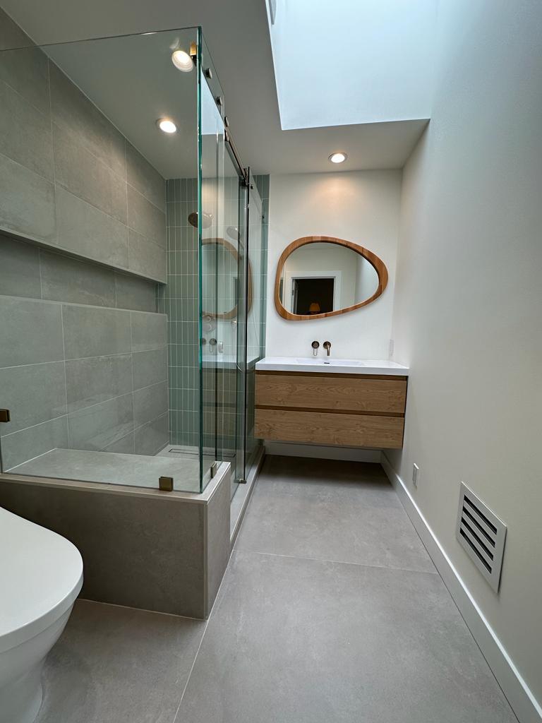 Organic asymmetrical bathroom mirror paired with natural stone in a Walnut Creek renovation